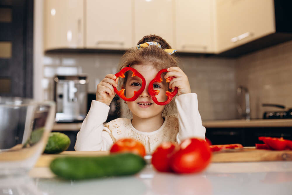 1783496103-cute-little-girl-preparing-salad-from-fresh-bell-pepper